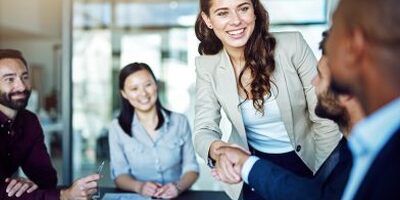Corporate meeting, woman shaking hands with colleague